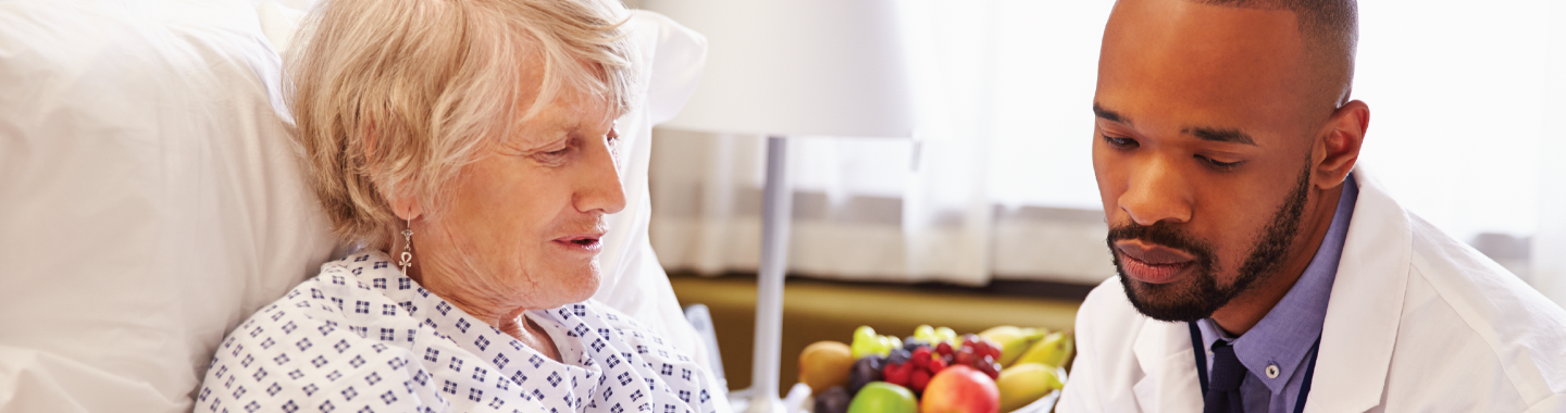 Woman in hospital bed speaking to doctor